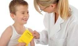 Auf dem Bild sind ein Junge und eine Ärztin mit einem Impfpass zu sehen