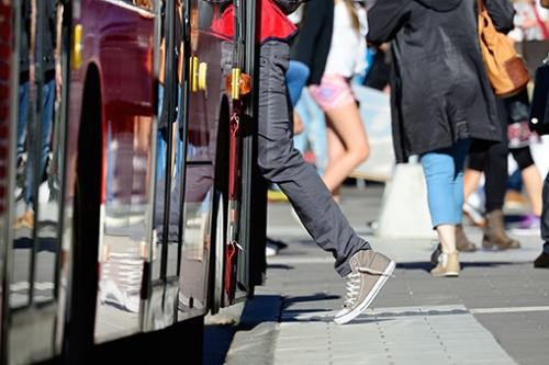 Bild zeigt eine Person, die in einen Bus einsteigt.